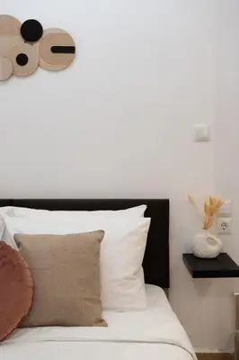 a white bed with a black headboard and some pillows at ARIS- Queen suite on the boulevard in Athens