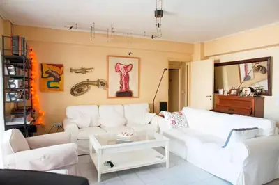 a living room with a white couch and a table at Stylish Apartment in the Heart of Nea Smyrni in Athens