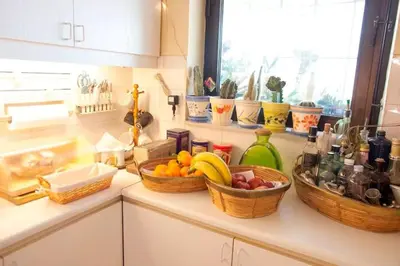 a kitchen counter with baskets of fruit and bottles at Stylish Apartment in the Heart of Nea Smyrni in Athens