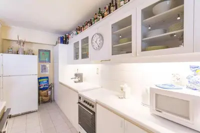 a kitchen with white cabinets and a white refrigerator at Stylish Apartment in the Heart of Nea Smyrni in Athens