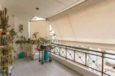 a room with a balcony with plants and a table at Stylish Apartment in the Heart of Nea Smyrni in Athens