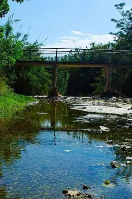 a bridge over a river with a bridge in the background at Cozy maisonette in Athinaiki Riviera of Palaio Faliro in Athens