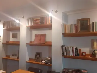 a room with wooden shelves with books at Cozy maisonette in Athinaiki Riviera of Palaio Faliro in Athens