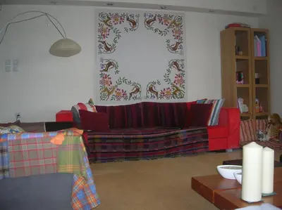 a living room with a red couch and a table at Cozy maisonette in Athinaiki Riviera of Palaio Faliro in Athens