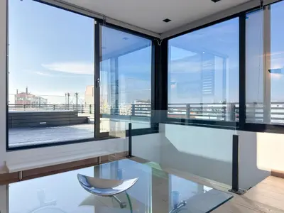 a glass table and a chair in a room with windows at Luxury Loft with Private Jacuzzi in Athens