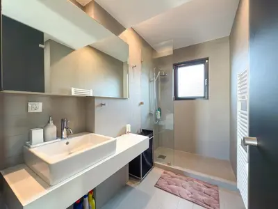 a bathroom with a large white sink and a shower at Luxury Loft with Private Jacuzzi in Athens