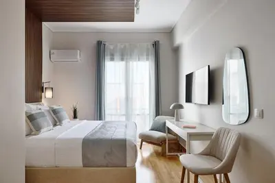 a bedroom with a bed and a desk and a mirror at Acropolis Museum Central Suite in Athens