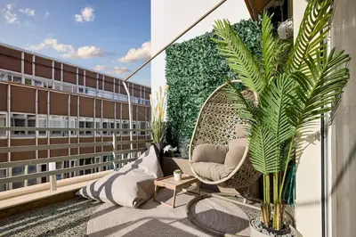 a balcony with a chair and plants on a building at Acropolis Museum Central Suite in Athens