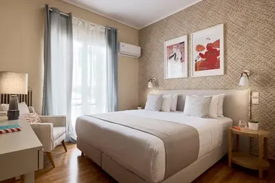 a bedroom with a large white bed and a chair at Acropolis Museum Central Suite in Athens