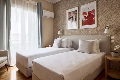 a bedroom with two beds and a window at Acropolis Museum Central Suite in Athens