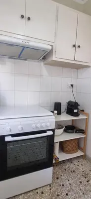 a kitchen with a stove and white cabinets at Bohemian Apartment Near The Museum And Exarchia in Athens