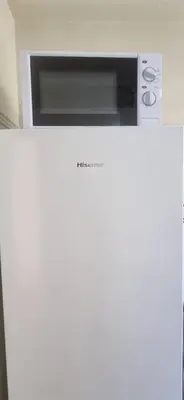 a microwave sitting on top of a white refrigerator at Bohemian Apartment Near The Museum And Exarchia in Athens