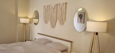 a bedroom with a bed and two mirrors on the wall at Bohemian Apartment Near The Museum And Exarchia in Athens