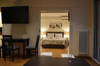 a bedroom with a bed and a table and a desk at Peaceful Retreat in Kolonaki in Athens