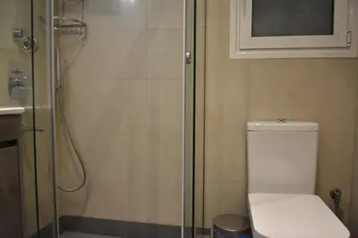 a bathroom with a toilet and a glass shower at Peaceful Retreat in Kolonaki in Athens