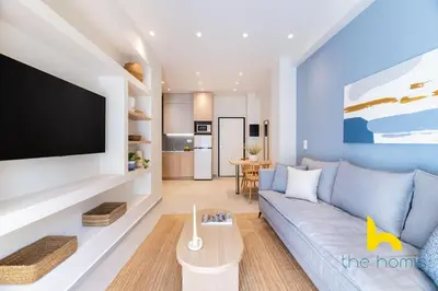 a living room with a blue couch and a flat screen tv at Koukaki Elegance - Athenian Retreat near Acropolis in Athens
