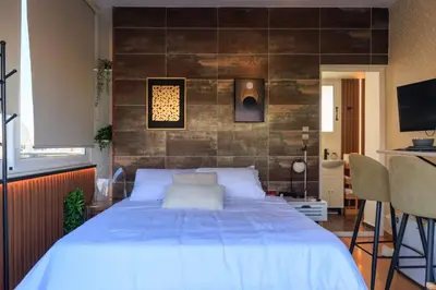 a bedroom with a large bed and a wall with tiles at AIOLOS Rooftop suite centre GLYFADA in Athens