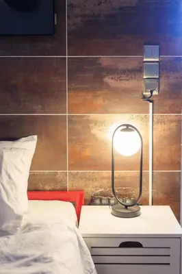 a lamp on a night stand next to a bed at AIOLOS Rooftop suite centre GLYFADA in Athens