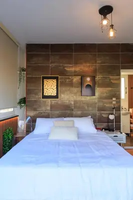 a bedroom with a large white bed with a wooden wall at AIOLOS Rooftop suite centre GLYFADA in Athens