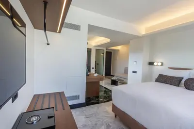 a bedroom with a white bed and a wooden table at L'Avventura Suites in Athens