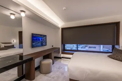 a hotel room with two beds and a large screen at L'Avventura Suites in Athens