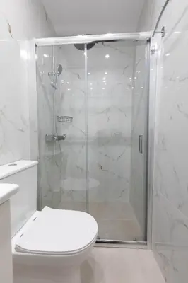 a white bathroom with a shower and a toilet at Boutique Apartment Τhe City Definition METRO 1 in Piraeus