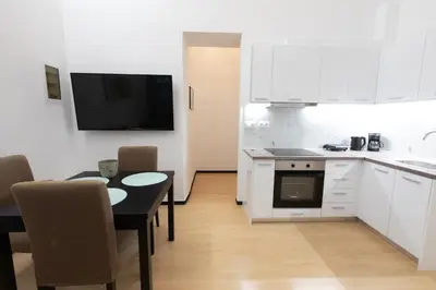 a kitchen with a table and a kitchen with white cabinets at Boutique Apartment Τhe City Definition METRO 1 in Piraeus