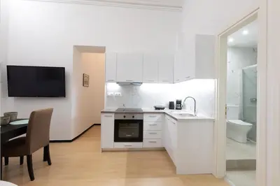 a white kitchen with a sink and a table at Boutique Apartment Τhe City Definition METRO 1 in Piraeus