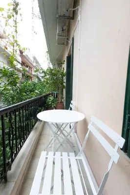 a white table and two chairs on a balcony at Boutique Apartment Τhe City Definition METRO 1 in Piraeus