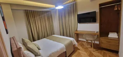 a bedroom with a bed and a desk and a television at New Ventiri Suite 6, near Hilton, Athens Central , 4 family & Bussines in Athens