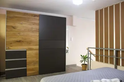 a bedroom with a large wooden wall next to a bed at New house in Piraeus in Piraeus