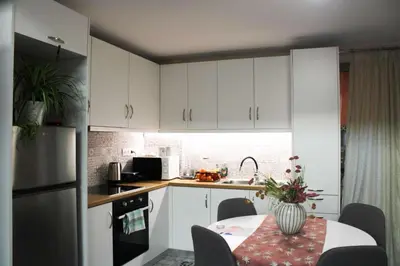 a kitchen with white cabinets and a table with a vase on it at New house in Piraeus in Piraeus