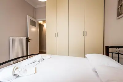 a bedroom with two beds and white cabinets at YOUR BRAND NEW Awesome Acropolis Home in Athens