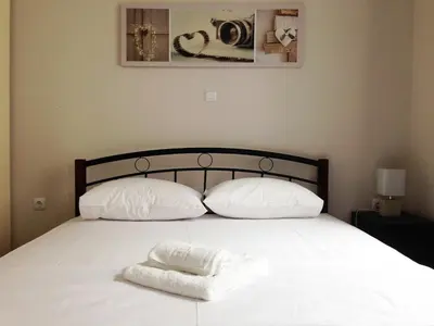 a bed with two pillows and a white towel on it at YOUR BRAND NEW Awesome Acropolis Home in Athens