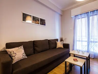 a living room with a brown couch and a table at YOUR BRAND NEW Awesome Acropolis Home in Athens