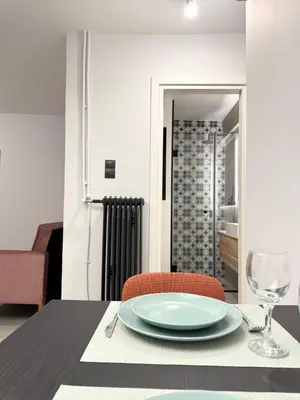 a dining room table with a plate and a glass at Cozy Apartment with Acropolis View Rooftop Access in Athens