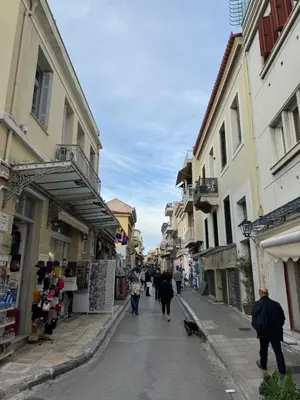 a group of people walking down a street with buildings at Cozy Apartment with Acropolis View Rooftop Access in Athens