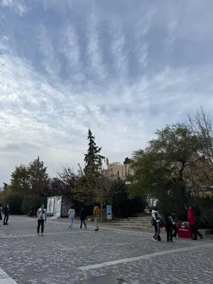 a group of people walking around in a park at Cozy Apartment with Acropolis View Rooftop Access in Athens