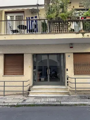 a building with a glass door with a balcony at Cozy Apartment with Acropolis View Rooftop Access in Athens