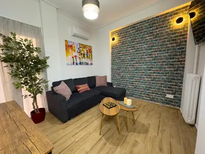 a living room with a couch and a brick wall at Koukaki Athens Cozy Home in Athens