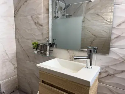 a bathroom with a white sink and a mirror at Koukaki Athens Cozy Home in Athens
