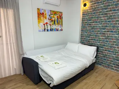 a bed in a room with a brick wall at Koukaki Athens Cozy Home in Athens