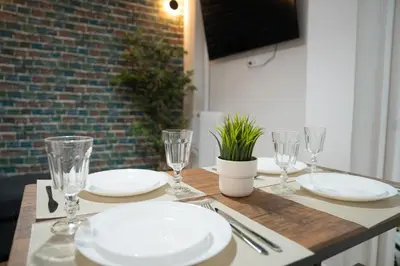 a table with plates and glasses on top of it at Koukaki Athens Cozy Home in Athens