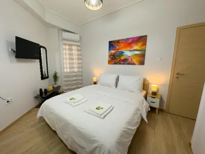 a bedroom with a white bed with two towels on it at Koukaki Athens Cozy Home in Athens