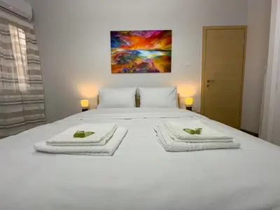 a bedroom with a white bed with towels on it at Koukaki Athens Cozy Home in Athens