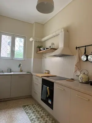 a kitchen with white cabinets and a stove top oven at Cozy apartment National Museum in Athens