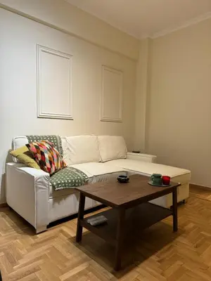 a living room with a couch and a coffee table at Cozy apartment National Museum in Athens