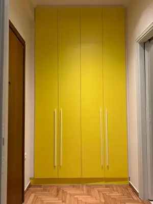 a yellow cabinet in a room with a wooden floor at Cozy apartment National Museum in Athens