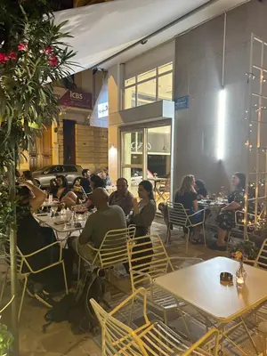 a group of people sitting at tables in a restaurant at Cozy apartment National Museum in Athens