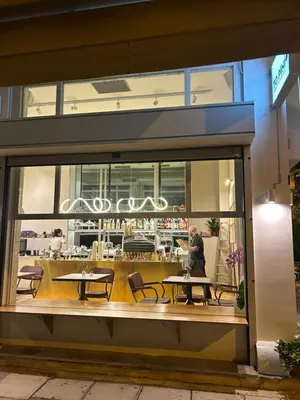 a restaurant with tables and chairs in a window at Cozy apartment National Museum in Athens